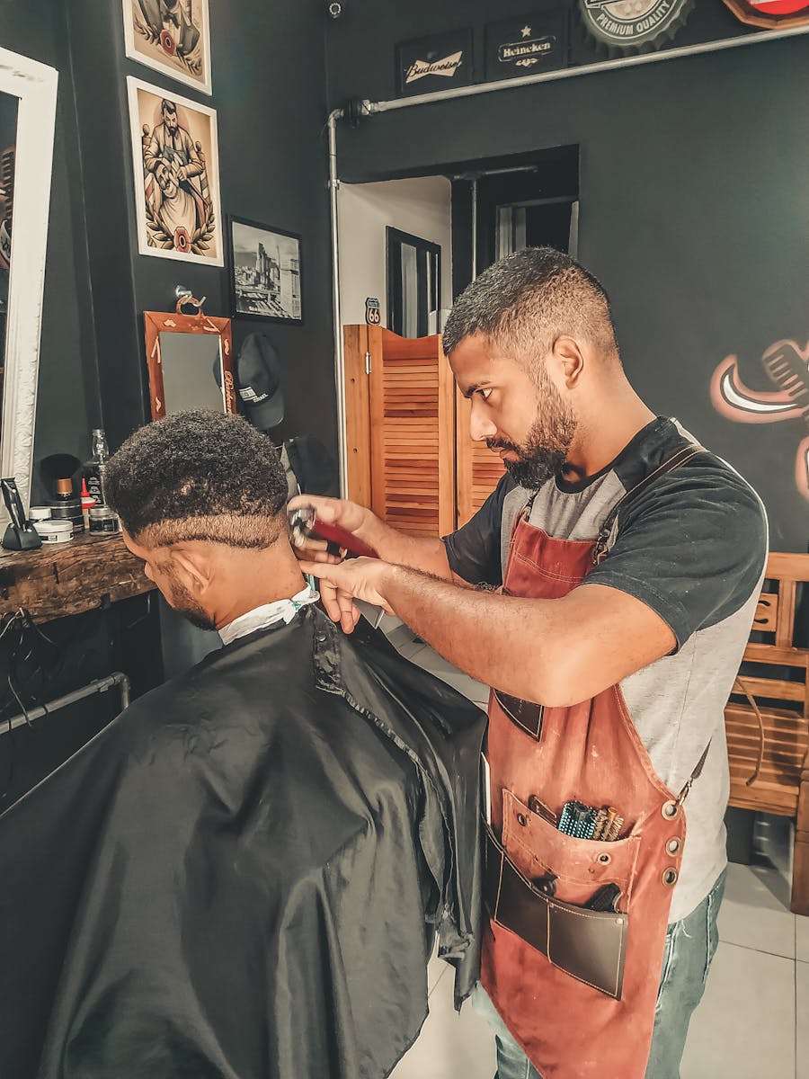 Experienced barber styling hair in a modern barbershop setting.